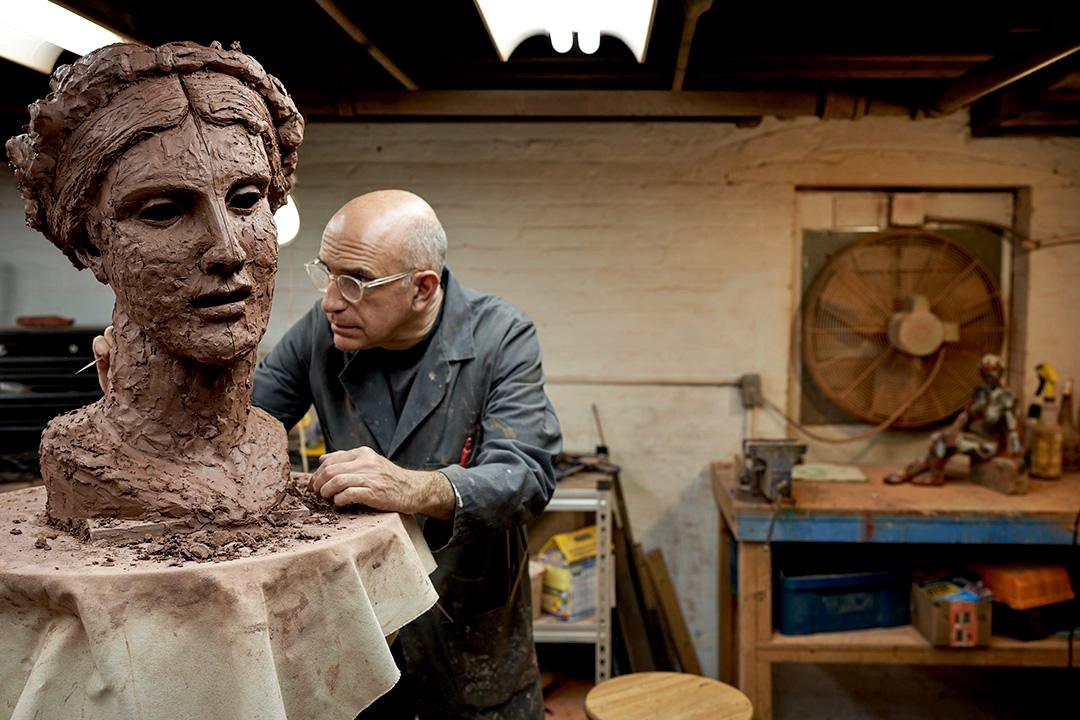 George Petrides modeling a clay head in the studio